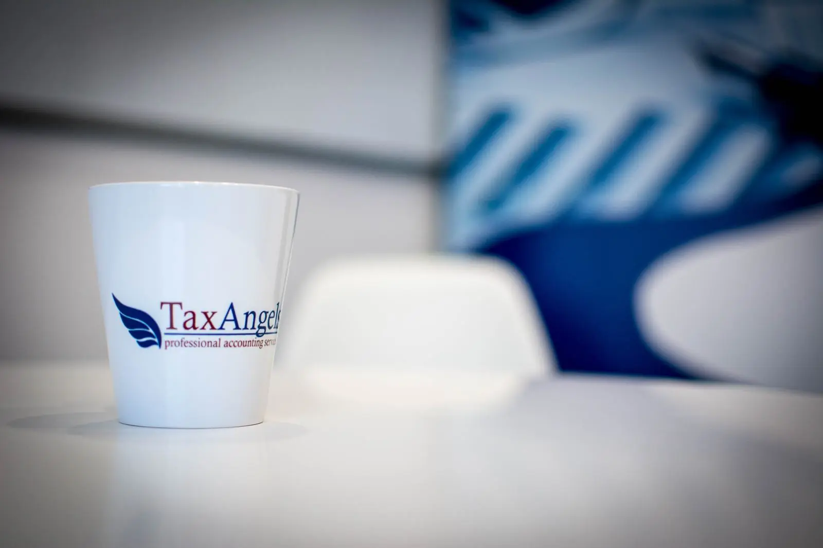 Kubek TaxAngels na stole w sali spotkań